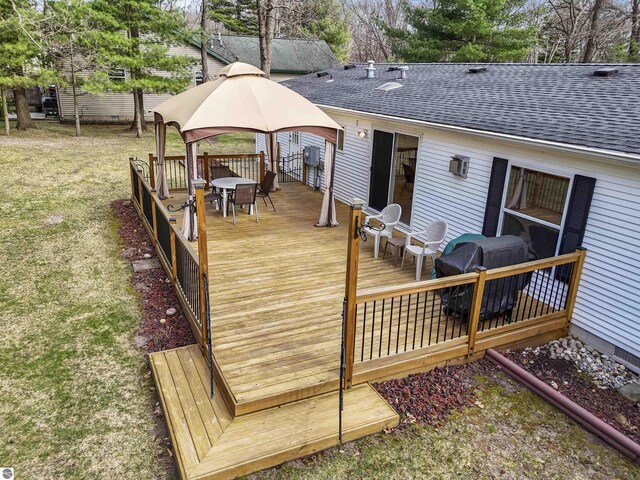 deck featuring outdoor dining space, a gazebo, and area for grilling