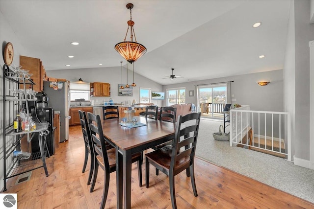 dining area featuring a healthy amount of sunlight, a ceiling fan, light wood-type flooring, and lofted ceiling