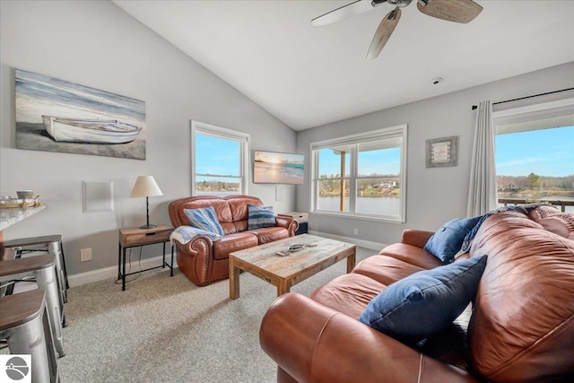 carpeted living room with baseboards, ceiling fan, vaulted ceiling, and a wealth of natural light