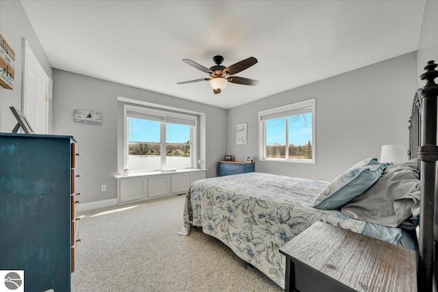 bedroom featuring ceiling fan, baseboards, multiple windows, and carpet floors