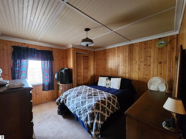 4320 Camp Rd, Oscoda, MI 48750 - bedroom with crown molding, wood walls, a closet, and light carpet