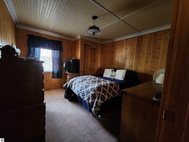 4320 Camp Rd, Oscoda, MI 48750 - bedroom with wooden walls, ornamental molding, light carpet, and a closet