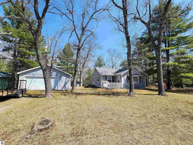 4320 Camp Rd, Oscoda, MI 48750 - view of front of home with a detached garage, an outdoor structure, a front lawn, and covered porch