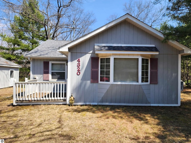 4320 Camp Rd, Oscoda, MI 48750 - view of front of home with a shingled roof and a front lawn