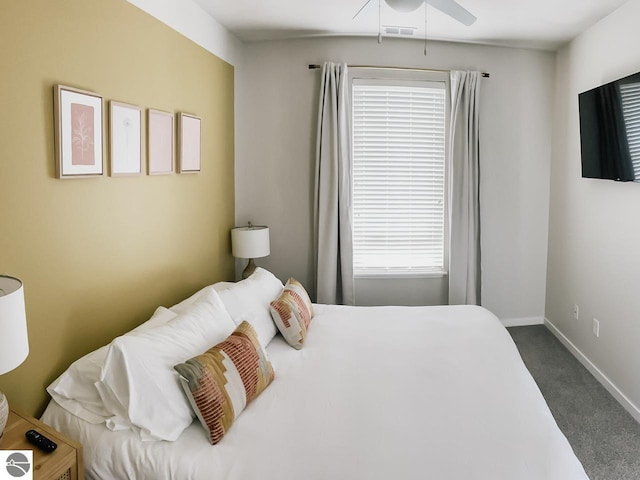 carpeted bedroom featuring baseboards, a ceiling fan, and visible vents