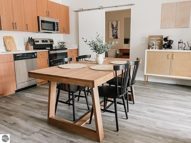 interior space with light wood-style floors, light countertops, and stainless steel appliances