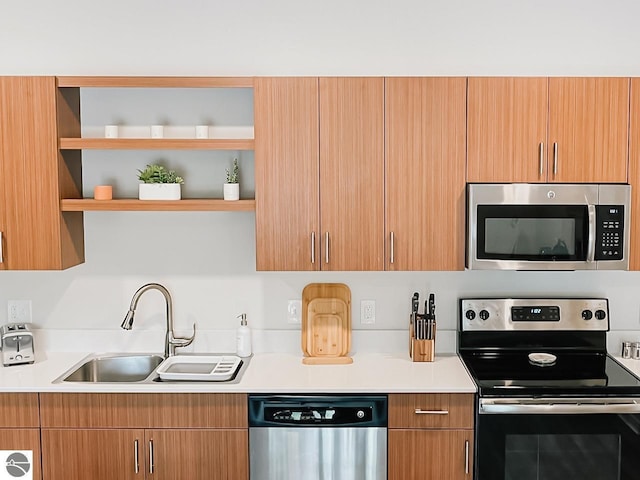 kitchen featuring light countertops, stainless steel appliances, open shelves, and a sink