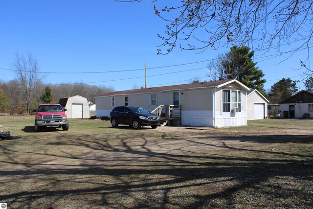 20122 Hayes Rd, Big Rapids, MI 49307 - manufactured / mobile home with a garage, an outbuilding, and a front yard
