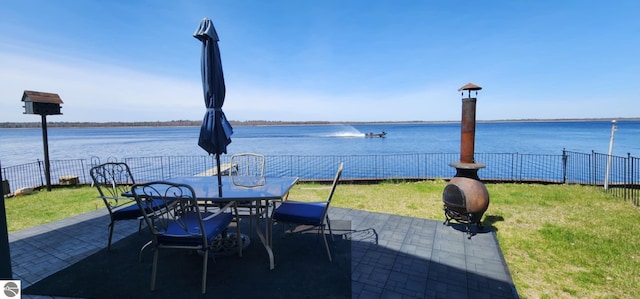 view of patio / terrace with a fenced backyard, outdoor dining area, and a water view