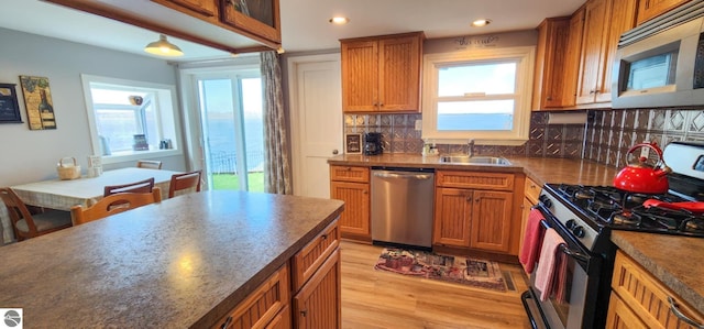 kitchen featuring light wood-style floors, recessed lighting, a sink, backsplash, and stainless steel appliances