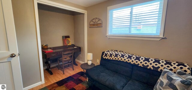living area featuring baseboards and wood finished floors