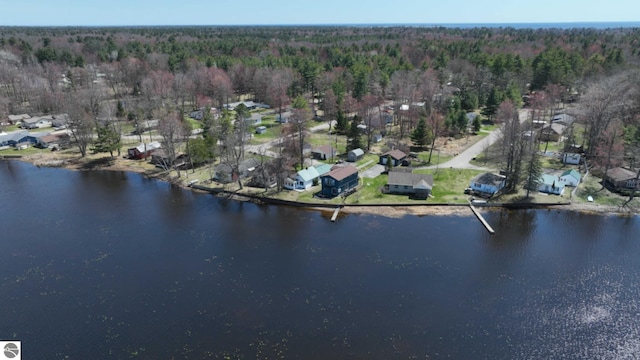 birds eye view of property featuring a water view, a residential view, and a wooded view