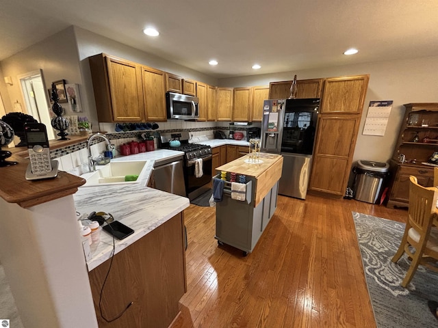 3633 Driftwood Dr, Cadillac, MI 49601 - kitchen with appliances with stainless steel finishes, a sink, wood-type flooring, recessed lighting, and butcher block countertops