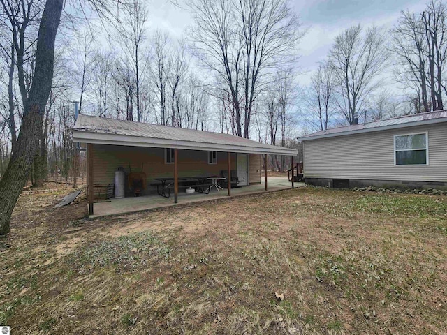 rear view of property with a patio, a carport, metal roof, and crawl space