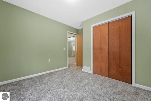 4326 Antioch Dr, Mesick, MI 49668 - unfurnished bedroom featuring baseboards, carpet, and a closet