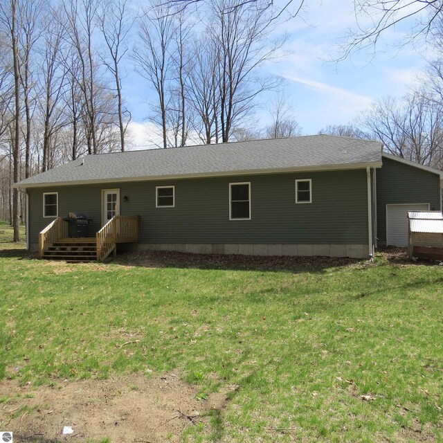 4326 Antioch Dr, Mesick, MI 49668 - back of house with a shingled roof, a wooden deck, and a yard
