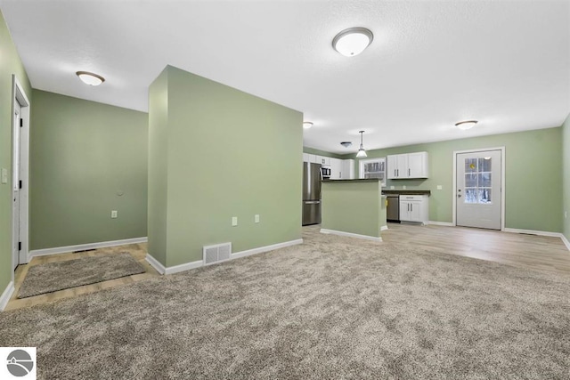 4326 Antioch Dr, Mesick, MI 49668 - unfurnished living room with light colored carpet, baseboards, and visible vents