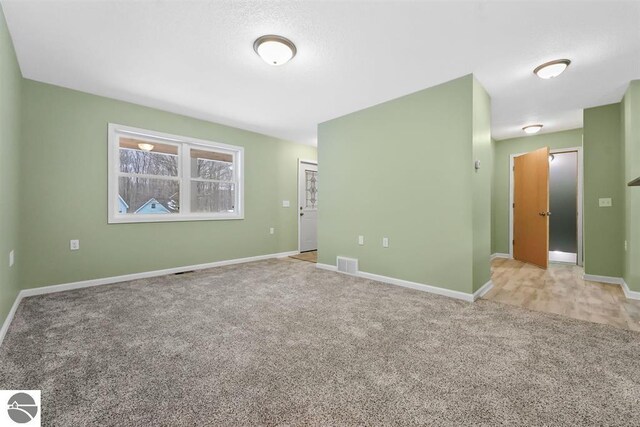 4326 Antioch Dr, Mesick, MI 49668 - spare room featuring light colored carpet, baseboards, and visible vents
