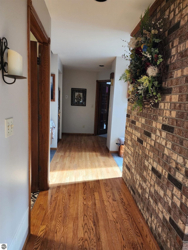 1697 Wildwood Rd, Sterling, MI 48659 - hallway with brick wall and wood finished floors