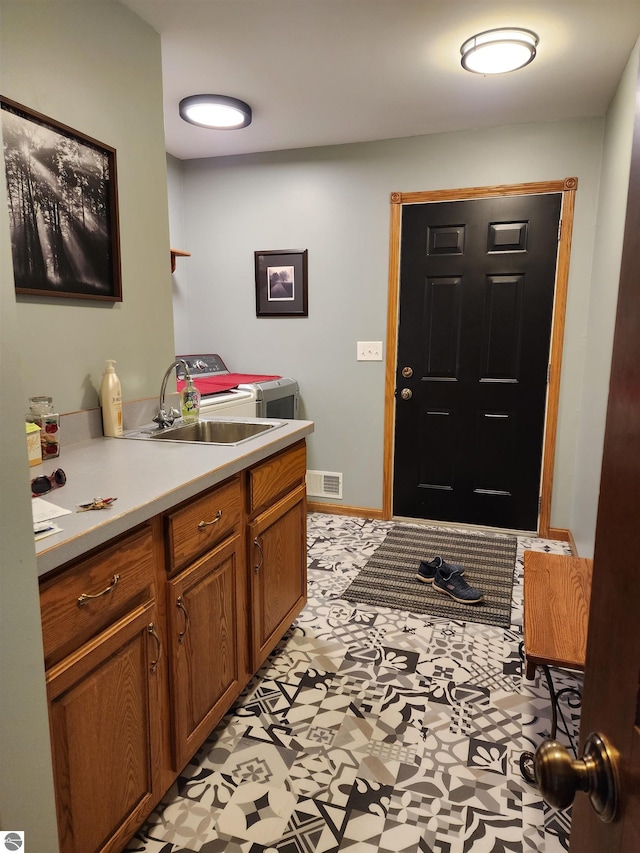 1697 Wildwood Rd, Sterling, MI 48659 - foyer featuring washing machine and clothes dryer, visible vents, and light floors