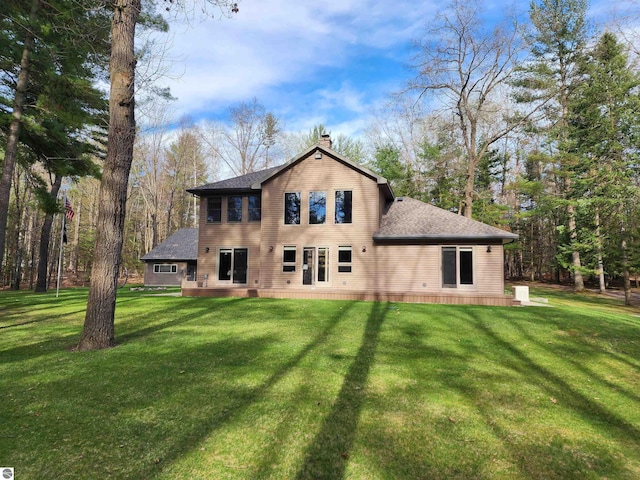 1697 Wildwood Rd, Sterling, MI 48659 - rear view of property featuring a shingled roof, a yard, and a chimney