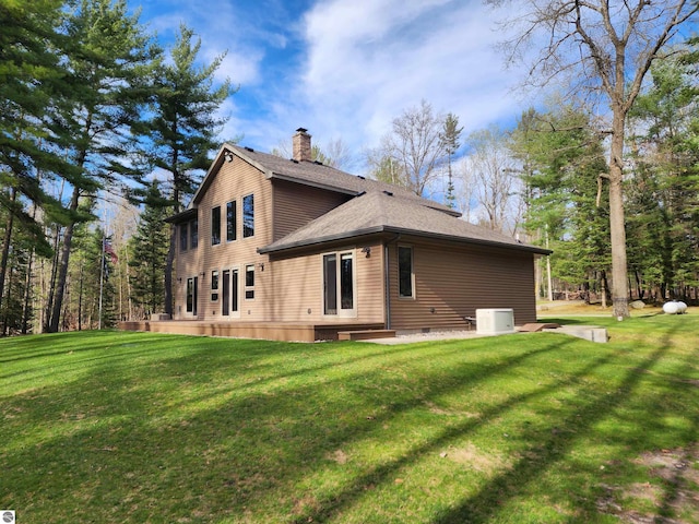 1697 Wildwood Rd, Sterling, MI 48659 - rear view of house with roof with shingles, a yard, and a chimney