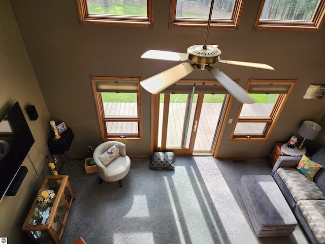 1697 Wildwood Rd, Sterling, MI 48659 - living area featuring carpet floors, ceiling fan, baseboards, and a high ceiling
