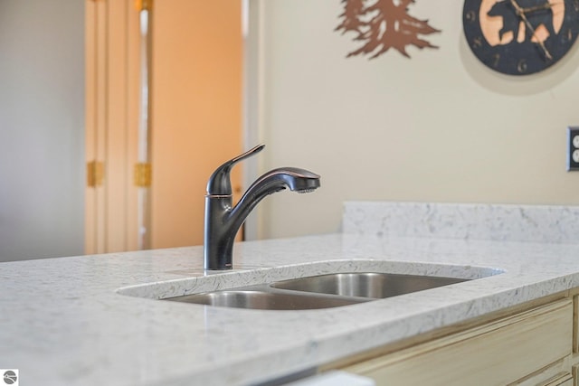 interior details with light stone counters and a sink