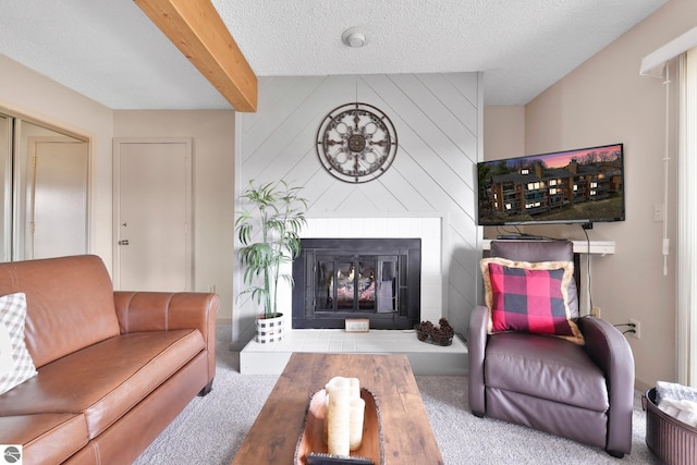 carpeted living room featuring beam ceiling, a fireplace, and a textured ceiling