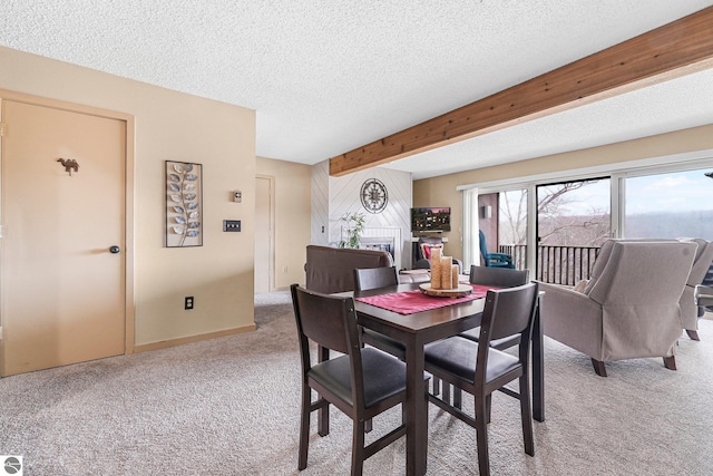 dining room with light colored carpet, a textured ceiling, baseboards, and beamed ceiling