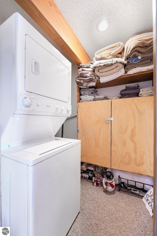 washroom featuring laundry area, stacked washer and clothes dryer, a textured ceiling, and carpet flooring