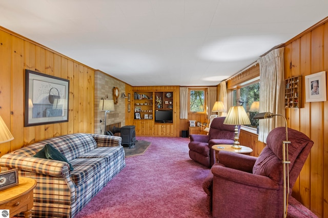 carpeted living room featuring wooden walls and a wood stove