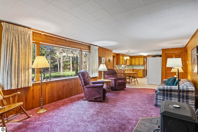 living area with light colored carpet and wood walls
