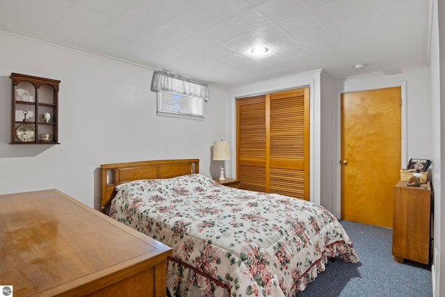 carpeted bedroom featuring ornamental molding and a closet