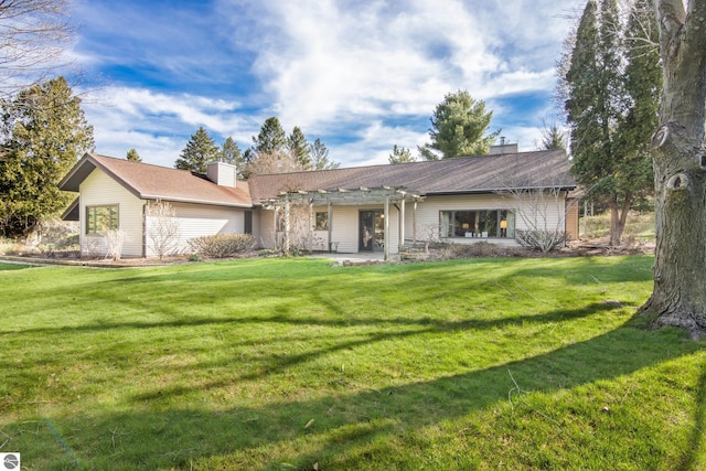 back of house with a pergola, a chimney, and a yard