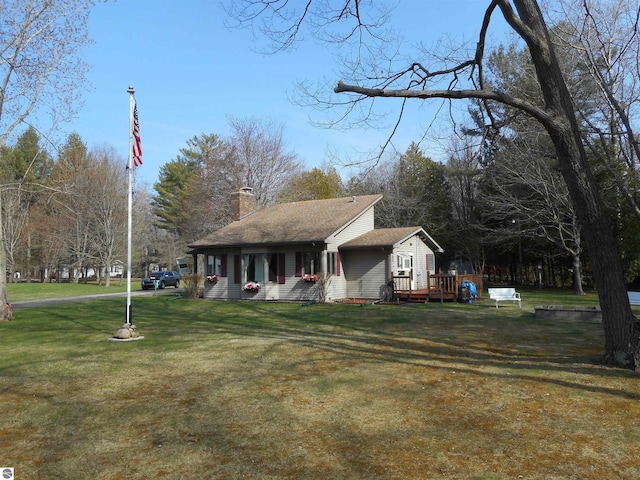 view of front of home featuring a wooden deck, a chimney, and a front lawn