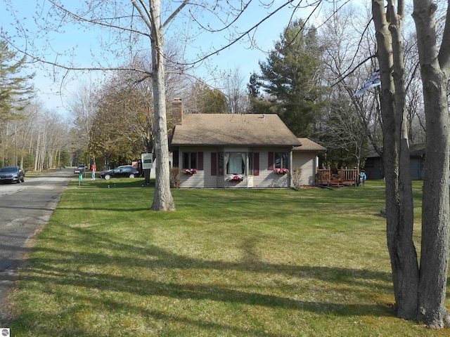 view of front facade featuring a chimney and a front yard
