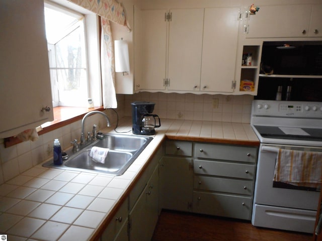 kitchen featuring tile countertops, tasteful backsplash, a sink, white electric range oven, and white cabinetry