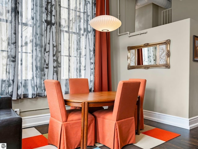 dining space featuring baseboards and wood finished floors