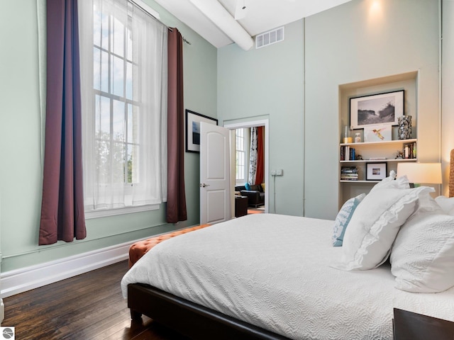 bedroom featuring baseboards, wood finished floors, and visible vents
