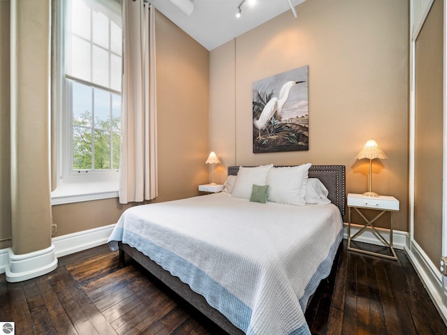 bedroom with baseboards and hardwood / wood-style flooring