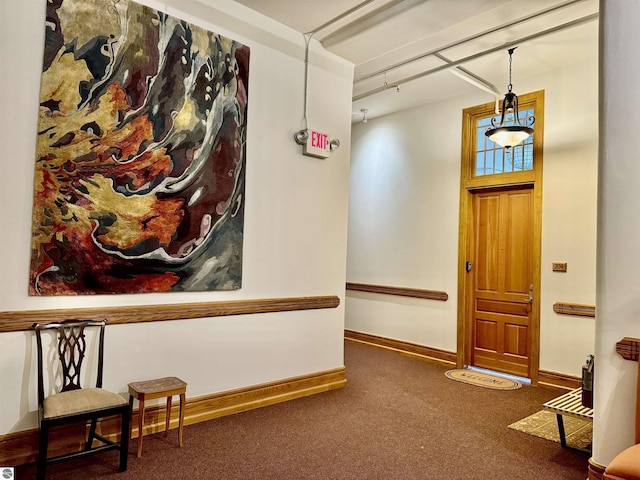 carpeted foyer entrance featuring baseboards