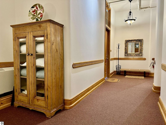 corridor with baseboards and carpet