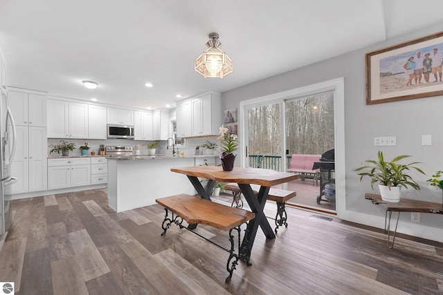 dining room with baseboards, recessed lighting, wood finished floors, and visible vents