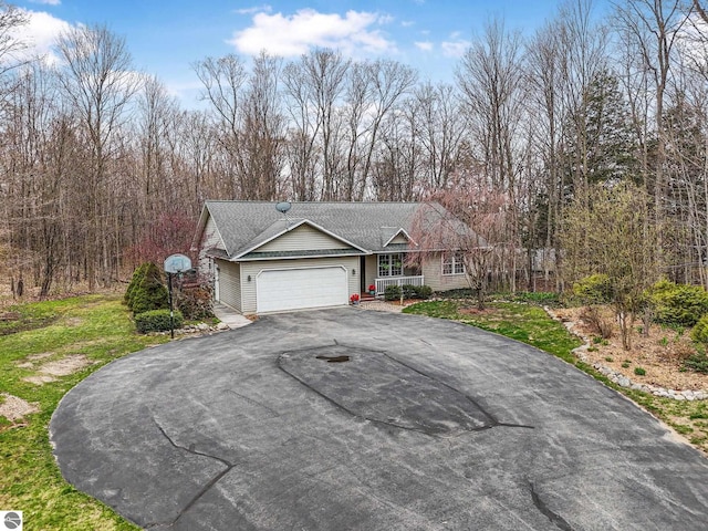 ranch-style house with a garage and aphalt driveway
