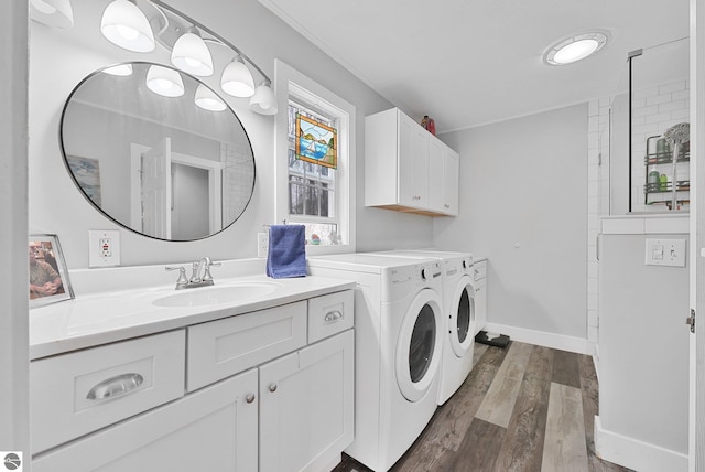 laundry area with cabinet space, a sink, separate washer and dryer, baseboards, and dark wood-style floors