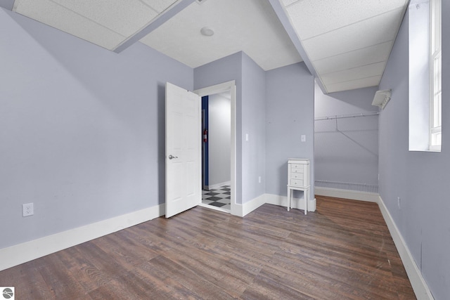 additional living space with baseboards and wood finished floors
