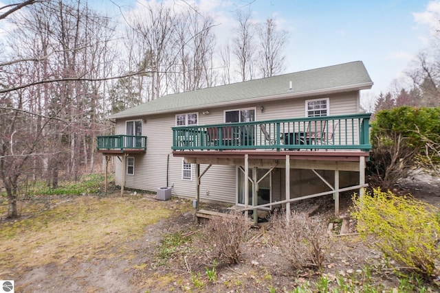back of house with roof with shingles, cooling unit, and a deck