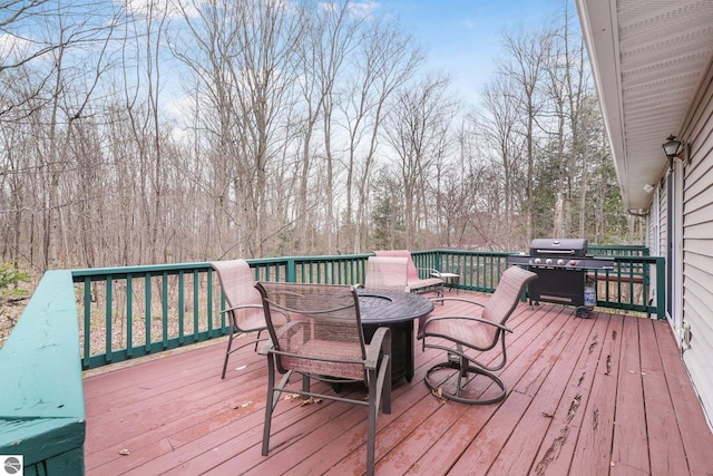wooden deck featuring grilling area and outdoor dining space