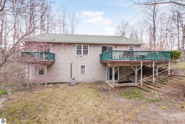 back of house featuring a lawn, central AC unit, and a wooden deck